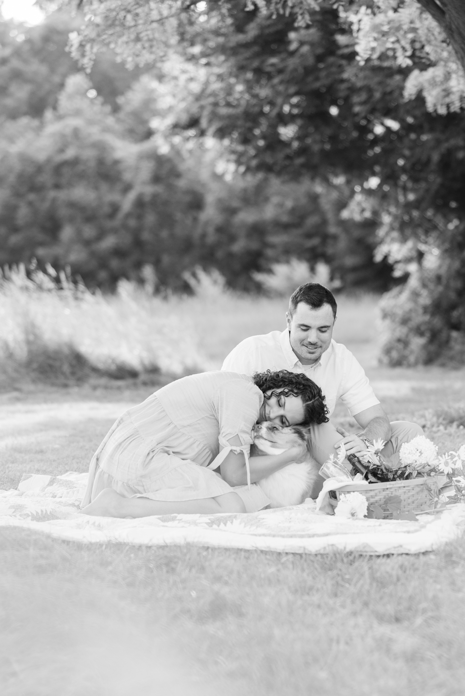 photo of engaged couple with dog at Sunset Picnic Engagement Session at Metea Park by Courtney Rudicel, a wedding photographer in Indiana