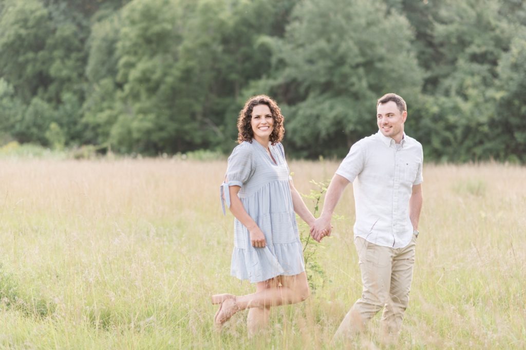 photo of couple walking in field at Sunset Engagement Session at Metea Park by Courtney Rudicel, a wedding photographer in Indiana