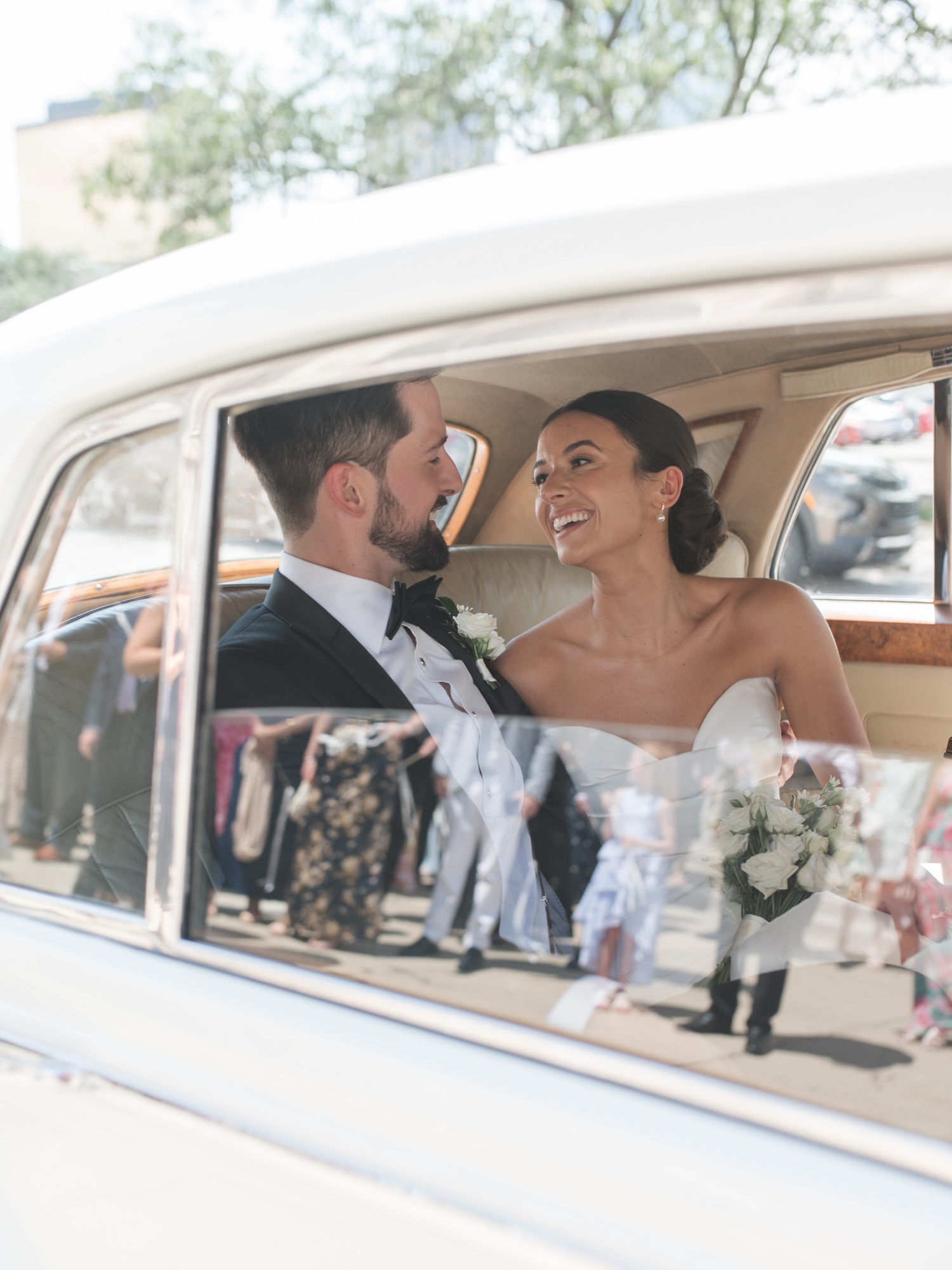 Bride smiling from a vintage Rolls Royce during her Bottleworks Hotel wedding in Indianapolis.