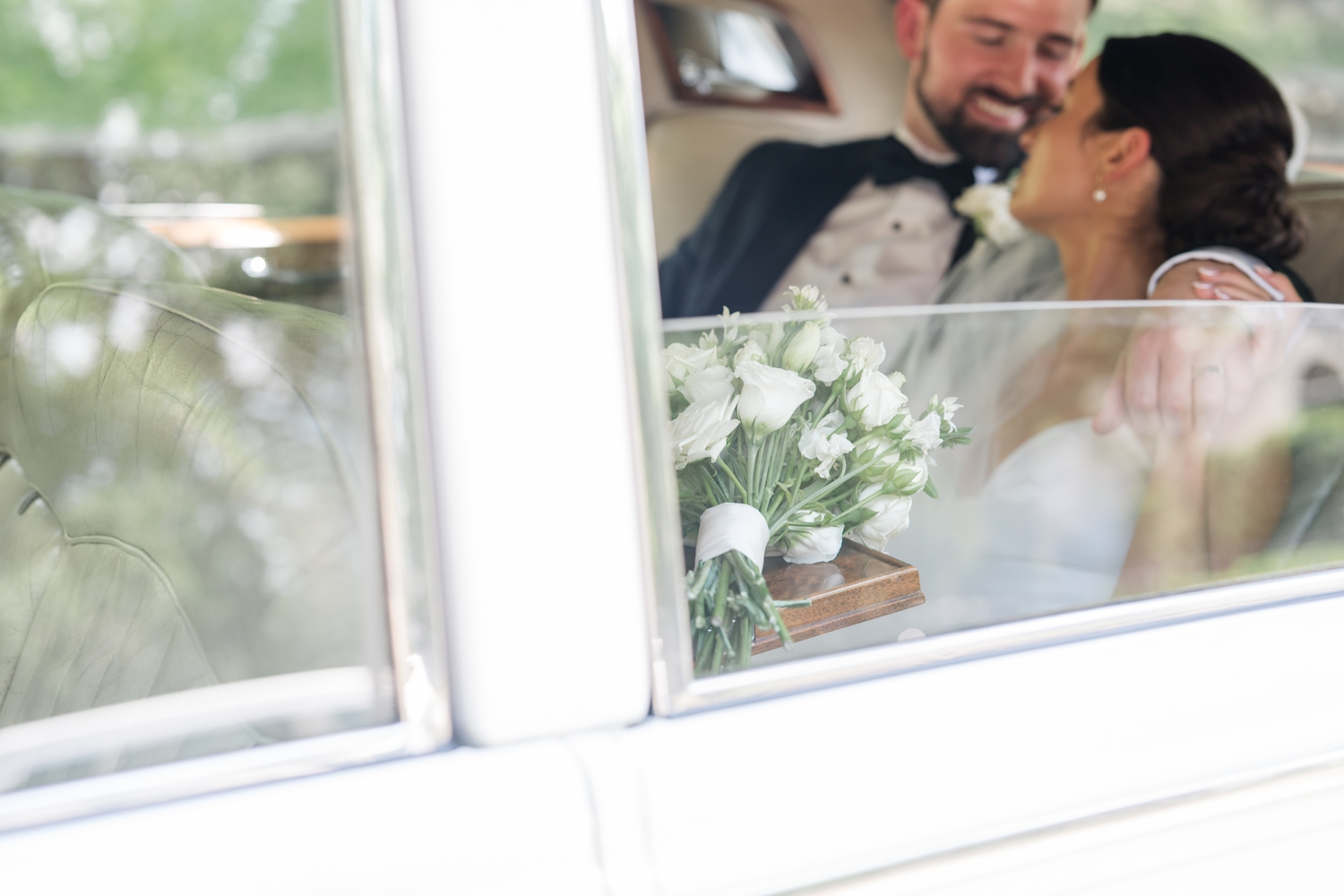 Bride smiling from a vintage Rolls Royce during her Bottleworks Hotel wedding in Indianapolis.