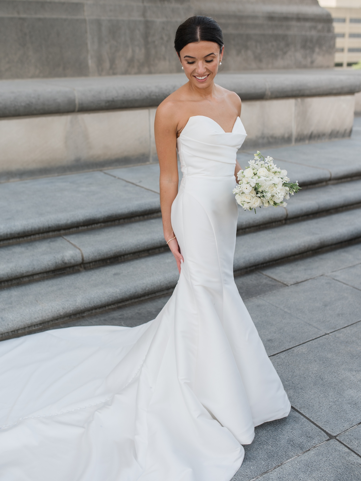 Bride in a strapless gown holding a white bouquet at Indianapolis War Memorial.