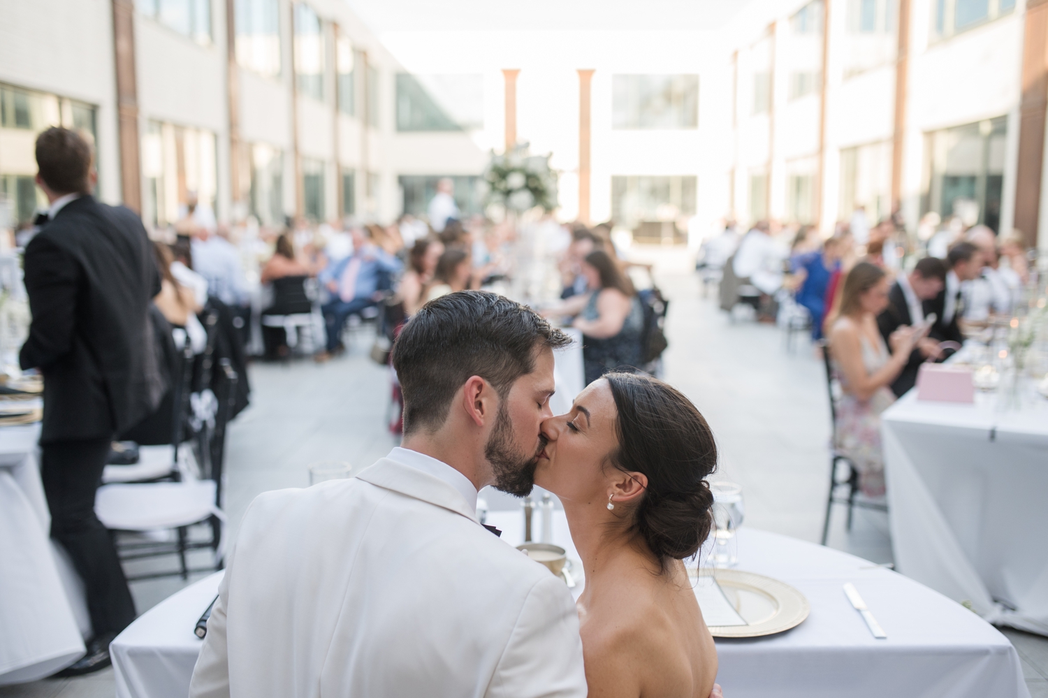 Al fresco reception setup at Bottleworks Hotel with white florals and candlelight.